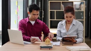 Müşteri ve emlakçı satın alma sözleşmesini tartışıyor. Arkaplan emlak vergisinde kira veya ev kredisi için gayrimenkul