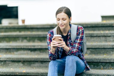 Üniversite öğrencileri teknoloji öğrenme fikirlerini tartışmak için dışarıda dizüstü bilgisayar ve tabletlerle çalışıyorlar..