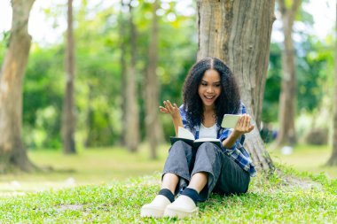 Üniversite öğrencileri teknoloji öğrenme fikirlerini tartışmak için dışarıda dizüstü bilgisayar ve tabletlerle çalışıyorlar..