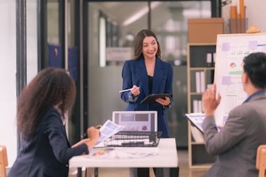 İş sunumu ya da seminerdeki konferans odasında evrak işleriyle uğraşan bir grup iş adamı. Takım çalışmasında masada duran belgelerle birlikte karar vermek için beyin fırtınası..