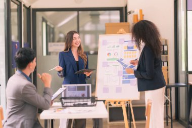 İş sunumu ya da seminerdeki konferans odasında evrak işleriyle uğraşan bir grup iş adamı. Takım çalışmasında masada duran belgelerle birlikte karar vermek için beyin fırtınası..