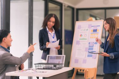 İş sunumu ya da seminerdeki konferans odasında evrak işleriyle uğraşan bir grup iş adamı. Takım çalışmasında masada duran belgelerle birlikte karar vermek için beyin fırtınası..