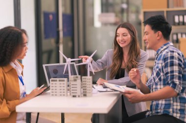 Bir satış temsilcisi, ofisteki iş arkadaşlarına güneş pillerinin nasıl çalıştığıyla ilgili bir sunum yapıyor. Güneş paneli pil konsepti üzerinde çalışan yenilenebilir enerji mühendislerinden oluşan bir ekiple toplantı..