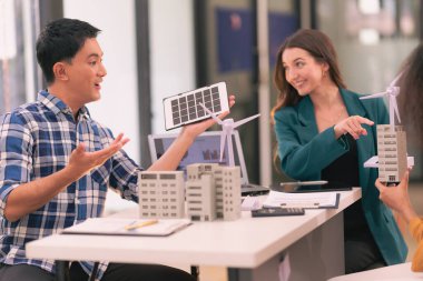 Bir satış temsilcisi, ofisteki iş arkadaşlarına güneş pillerinin nasıl çalıştığıyla ilgili bir sunum yapıyor. Güneş paneli pil konsepti üzerinde çalışan yenilenebilir enerji mühendislerinden oluşan bir ekiple toplantı..