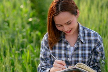 Asyalı çiftçi buğday tarlasında defter tutuyor pirinç tarlasında çalışıyor tarım ve hasat kavramı
