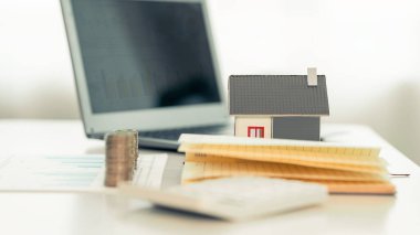 Yığınla madeni para ve oyuncak ev, kredi, fon ve yatırım kârı olan bir domuz bankası tarafından ev satın alınması fikri. Sağlık sigortası için para biriktirilen, yakın plan resimler.