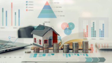 Yığınla madeni para ve oyuncak ev, kredi, fon ve yatırım kârı olan bir domuz bankası tarafından ev satın alınması fikri. Sağlık sigortası için para biriktirilen, yakın plan resimler.