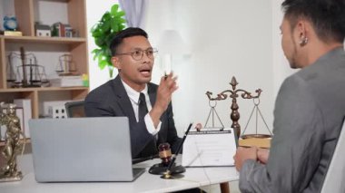 İş adamı ve avukat konuşuyor ve birlikte sözleşme yapıyorlar. Yasal bir belge imzalayıp, masaya çekiç koyuyorlar. Yasal konsept. İşlem. Çalışma ortamı.