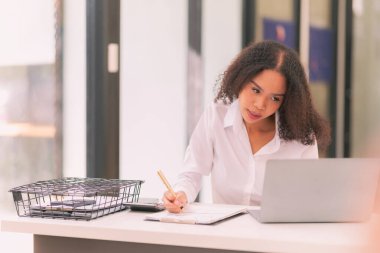 Ofis internet teknolojisi şirketinde çalışmak için dizüstü bilgisayar kullanan başarılı bir iş kadını: Millennial kadın profesyonel çalışan iş yerinde dizüstü bilgisayarında e-posta yazıyor.