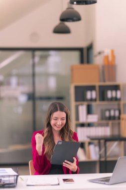 Ofis internet teknolojisi şirketinde çalışmak için dizüstü bilgisayar kullanan başarılı bir iş kadını: Millennial kadın profesyonel çalışan iş yerinde dizüstü bilgisayarında e-posta yazıyor.