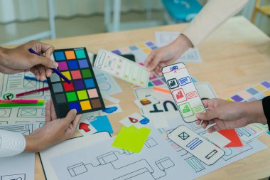 UX / UI tasarımcıları web sitesi ve mobil uygulama prototipleri ve uygulama tasarım fikirleri için beyin fırtınası düzenlerini tartışıp tartışırlar. Yakın plan..