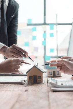 Bayan emlakçı ofisteki ev ve model inşaatı projeleriyle ilgili bilgi veriyor ve sunuyor..