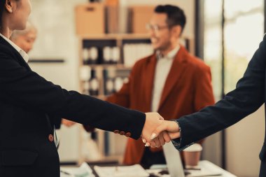 Bir grup genç iş adamı toplanıyor, el sıkışıyor ve ofiste kendilerini tanıtıyorlar. Farklı ülkelerden iş ortakları birbirlerini selamlıyorlar..