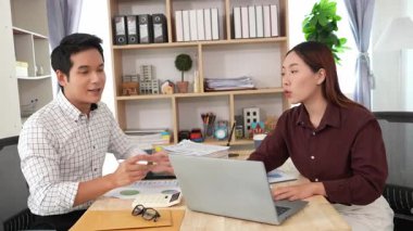 Ev konferans odasında yapılan toplantı sırasında artan satış, gelir ve kâr verilerini inceleyen ve analiz eden iki işadamı ve kadının görüntüsü.