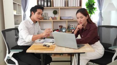 Ev konferans odasında yapılan toplantı sırasında artan satış, gelir ve kâr verilerini inceleyen ve analiz eden iki işadamı ve kadının görüntüsü.