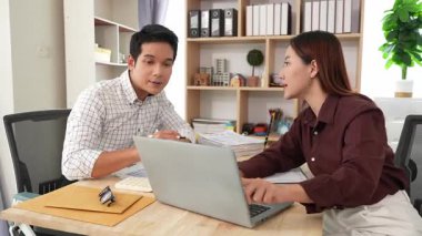 Ev konferans odasında yapılan toplantı sırasında artan satış, gelir ve kâr verilerini inceleyen ve analiz eden iki işadamı ve kadının görüntüsü.