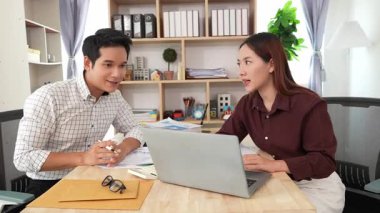 Ev konferans odasında yapılan toplantı sırasında artan satış, gelir ve kâr verilerini inceleyen ve analiz eden iki işadamı ve kadının görüntüsü.