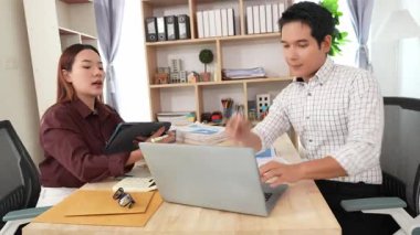 Ev konferans odasında yapılan toplantı sırasında artan satış, gelir ve kâr verilerini inceleyen ve analiz eden iki işadamı ve kadının görüntüsü.