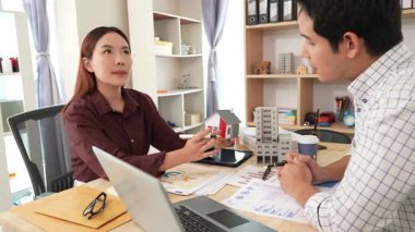 İki işadamı ev satın alma sözleşmelerini ve emlak ipoteği anlaşmalarını tartışıyor ve ev ofisinin planlarını anlatıyor.