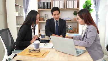 İş adamları proje stratejisini tartışırken dizüstü bilgisayarla beyin fırtınası yapıyor. Ortak atmosfer.