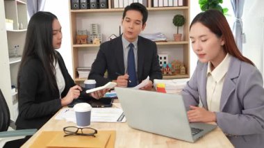 İş adamları proje stratejisini tartışırken dizüstü bilgisayarla beyin fırtınası yapıyor. Ortak atmosfer.