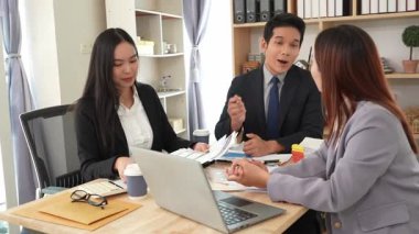 İş adamları proje stratejisini tartışırken dizüstü bilgisayarla beyin fırtınası yapıyor. Ortak atmosfer.