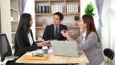 İş adamları proje stratejisini tartışırken dizüstü bilgisayarla beyin fırtınası yapıyor. Ortak atmosfer.