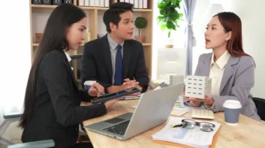 Emlakçı borç para alıyor ve bir mülk için nakit ödüyor. Emlakçı müşterilere ev planlarını sunar. Ev alırken ya da satarken karı koca.