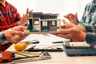 Makine planlarını analiz etmek, mimari projeleri tartışmak, inşaat planlarını gözden geçirmek ve konferans masasındaki tabletleri kullanarak bina planlarını gözden geçirmek için Endüstriyel Mühendisler ekibi toplantısına yakın plan.