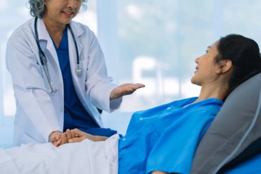 Asyalı kadın doktor evde yaşlı bir hastaya danışmanlık yapıyor, teşhis ve tedavi planını anlatıyor, yaşlı kadınlara sağlık hizmeti veriyor, sağlık konsepti