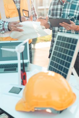 Mühendisler ve inşaat işçileri veya ev planları, konut binaları veya emlak veya mimari yenilik ofisleri. İnşaat alanındaki insanlar, yakın çekim..