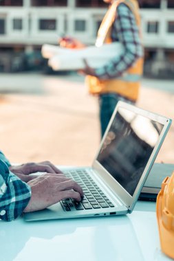 Mühendisler ve inşaat işçileri veya ev planları, konut binaları veya emlak veya mimari yenilik ofisleri. İnşaat alanındaki insanlar, yakın çekim..