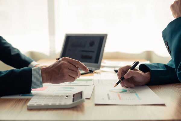 Закрытие рук бизнес-команды во время обсуждения. Финансовые диаграммы и графики на столе. Успешная командная работа. Деловая встреча.