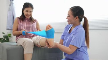 Üst düzey bir kadın, genç bir hemşireyle egzersiz yapıyor. Yaşlı bir kadına evde koltukta oturmasında yardım ediyor. Sağlık danışmanlığı, fizik tedavi konsepti.