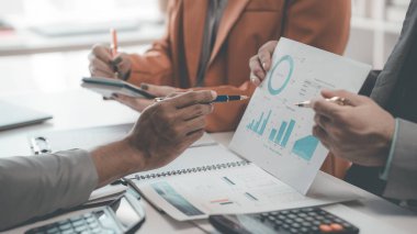 İş adamları başarılı takım çalışmalarının sonuçlarını gösteren çizelgeler ve grafikler hakkında konuşuyorlar. Takım çalışmasının sonuçlarını gösteren iş büyümesi.