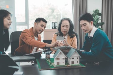 Yatırım anlaşması imzalayan bir iş adamı. Takım elbiseli profesyoneller, mali anlaşma belgeleriyle ofiste toplanıyor..