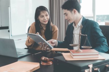 Erkek ve kadın avukatlar konferans masasında sözleşme belgeleriyle ve mahkeme masasındaki tahta çekiçle belgeleri tartışıyorlar. Adalet ve hukuk. Avukat..