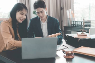 Erkek ve kadın avukatlar konferans masasında sözleşme belgeleriyle ve mahkeme masasındaki tahta çekiçle belgeleri tartışıyorlar. Adalet ve hukuk. Avukat..