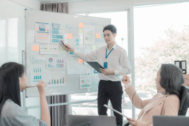 Asyalı iş adamları başarılı takım çalışmalarının sonuçlarını, yatırımları ve takım çalışmasının sonuçlarını gösteren grafikleri ve grafikleri tartışıyor..