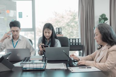 Asyalı iş adamları başarılı takım çalışmalarının sonuçlarını, yatırımları ve takım çalışmasının sonuçlarını gösteren grafikleri ve grafikleri tartışıyor..