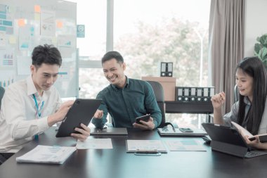 Asyalı iş adamları başarılı takım çalışmalarının sonuçlarını, yatırımları ve takım çalışmasının sonuçlarını gösteren grafikleri ve grafikleri tartışıyor..