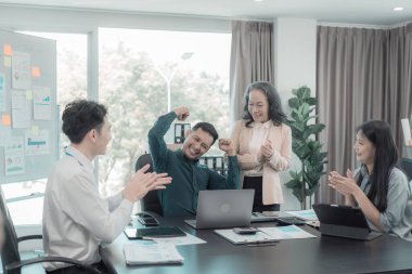 Bir grup başarılı iş adamı resmi takım elbiseler giyip, mutlu mesut ellerini kaldırarak başarılarını kutluyorlar..