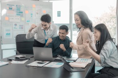 Bir grup başarılı iş adamı resmi takım elbiseler giyip, mutlu mesut ellerini kaldırarak başarılarını kutluyorlar..