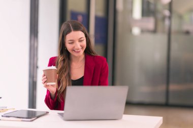 Ofiste dizüstü bilgisayarda çalışan ciddi iş kadını, e-postaları okuyor, online sunumları izliyor, pazarlama raporlarını analiz ediyor..