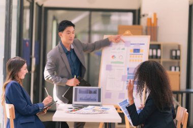 Bir grup iş adamı, ofiste tabletle çalışan grafik tasarımlı başarılı takım çalışmasının sonucunu temsil eden bir ürün tasarlıyor..