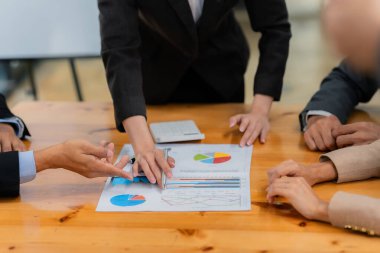 İş adamları başarılı takım çalışmalarının sonuçlarını gösteren çizelge ve grafikleri tartışıyor. İş ortaklarının iş stratejisi hakkındaki mali verileri analiz etmeleri.