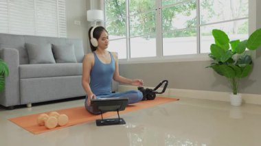 Sağlık, fitness konsepti. Aktif Asyalı bayan sporcu evde egzersiz yapıyor, mindere oturuyor. Spor ve spor rutini.