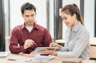 Emlakçılar müşterilerine bir konferans odasında ev planları gösteriyorlar. Alıcılar iş sözleşmelerini ev ofisinde imzalarlar ve kira, konut kredisi veya ev sigortası almaktan tasarruf etmeyi tartışırlar.