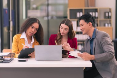 Takım çalışmasının sonuçlarını gösteren çizelge ve grafikleri tartışan bir grup iş stratejisi hakkında modern ofiste finansal verileri analiz eden bir grup iş adamı..