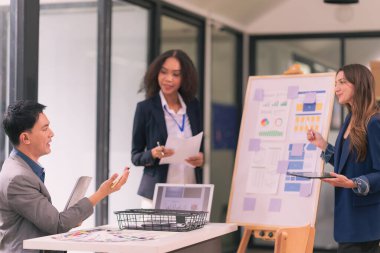 Takım çalışmasının sonuçlarını gösteren çizelge ve grafikleri tartışan bir grup iş stratejisi hakkında modern ofiste finansal verileri analiz eden bir grup iş adamı..